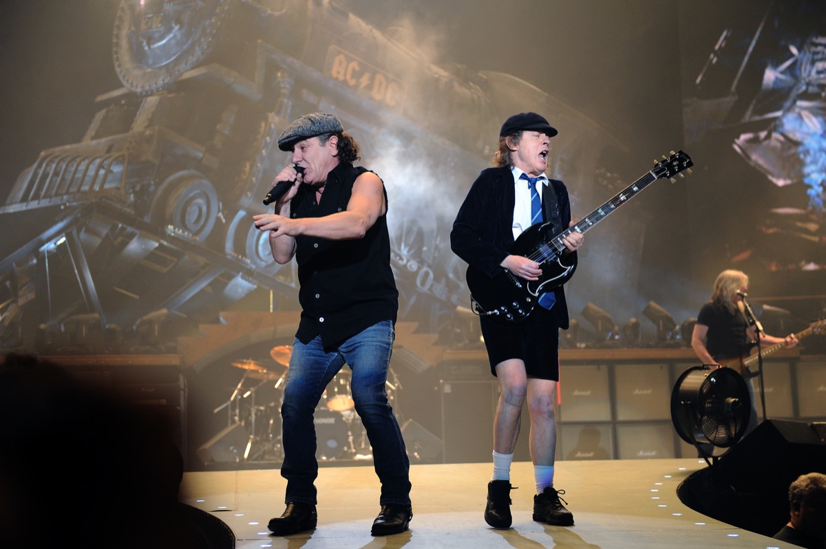 Australian rock group Ac/DC performing on stage, bands streaming