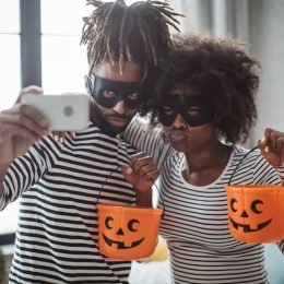 Young couple celebrating Halloween. They wear costumes, smiling, taking selfie and enjoy in holiday, diy halloween costume