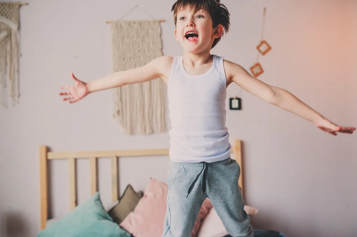 boy jumping on bed in the morning. 