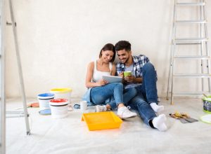 a couple paints a room