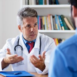 mature doctor talking to his patient looking confused