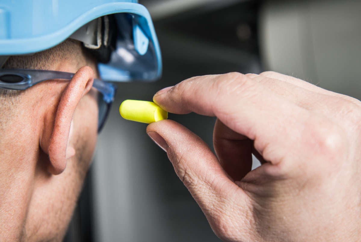 Man putting in ear plugs prevent health issues aging