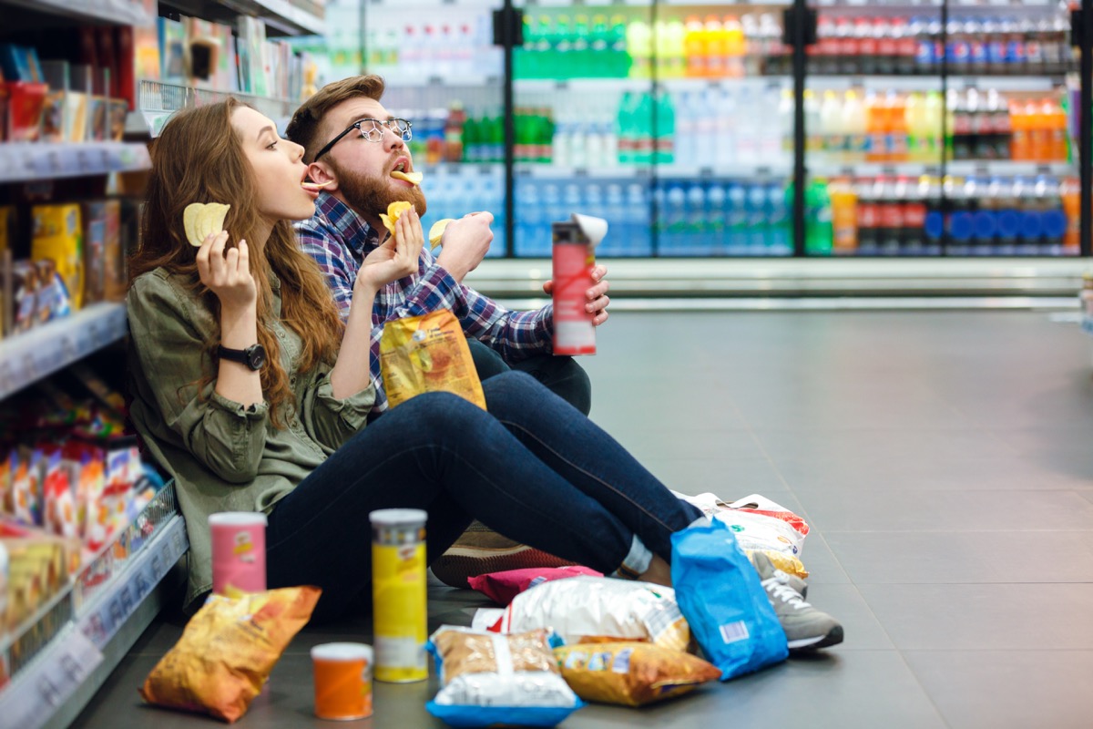 man and woman eating junk food