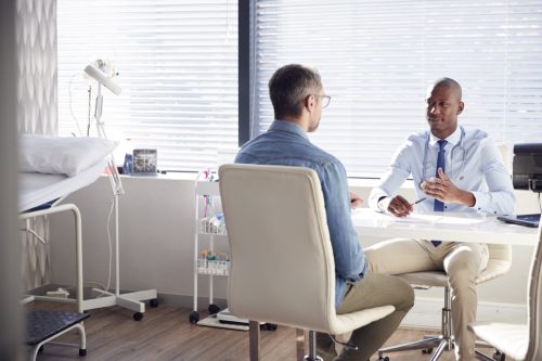 Doctor bărbat vorbind cu pacientul său de sex masculin