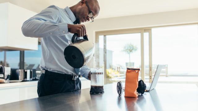 Man pouring from a coffee pot in the office, ways you're damaging teeth