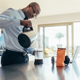 Man pouring from a coffee pot in the office, ways you're damaging teeth