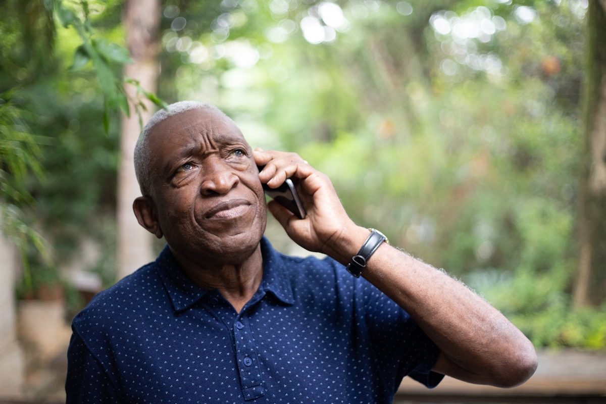 older man trying to call someone on his cell phone