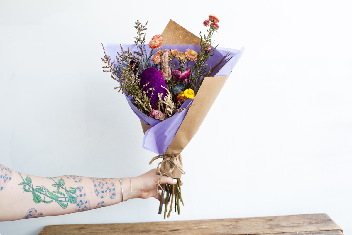 white tattooed arm holding dried bouquet