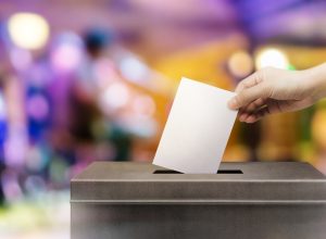 Person submitting their vote in a ballot box Emmys Facts