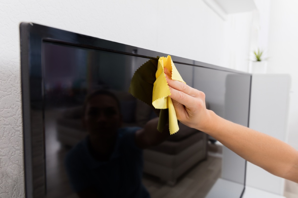 woman dusting TV, fire prevention tips