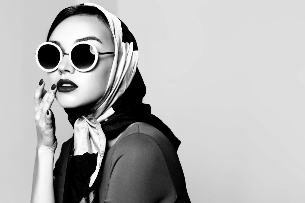 woman in big sunglasses and a headscarf in black and white vintage shot