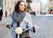 woman in gray coat on bicycle outside, best winter coats for women