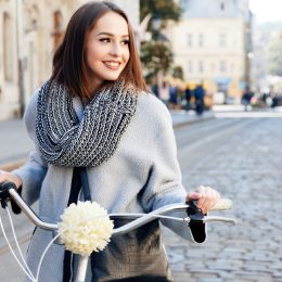 woman in gray coat on bicycle outside, best winter coats for women