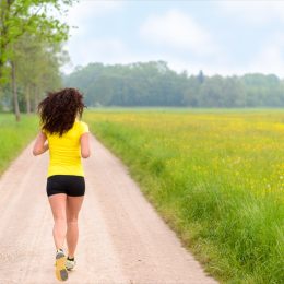 Woman running in a park or farmland area with nobody around town no traffic lights