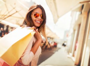 woman holding shopping bags and wearing sunglasses, end of summer sales 2019