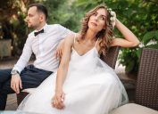 Newlywed bride and groom sitting on a sofa angry at each other in a middle of an argument.