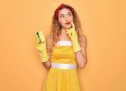 Woman in yellow dress with sponge and cleaning gloves