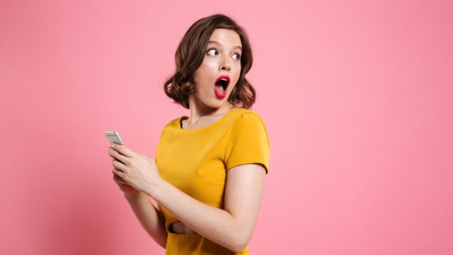 Shocked woman holding phone