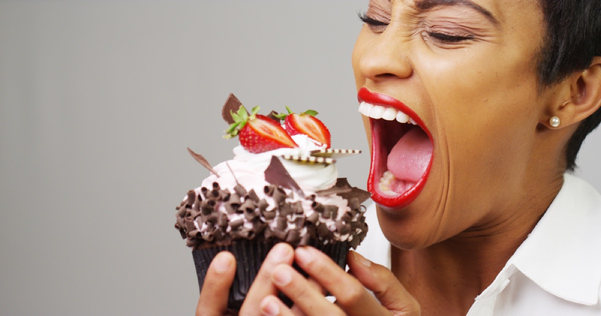 black woman eating chocolate cupcake
