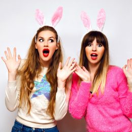 Two women taking a photograph wearing bunny ears