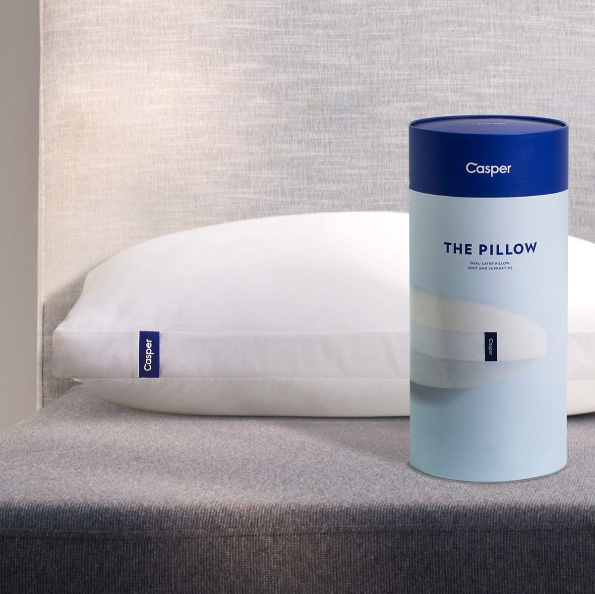 white casper pillow and blue cylindrical case next to it