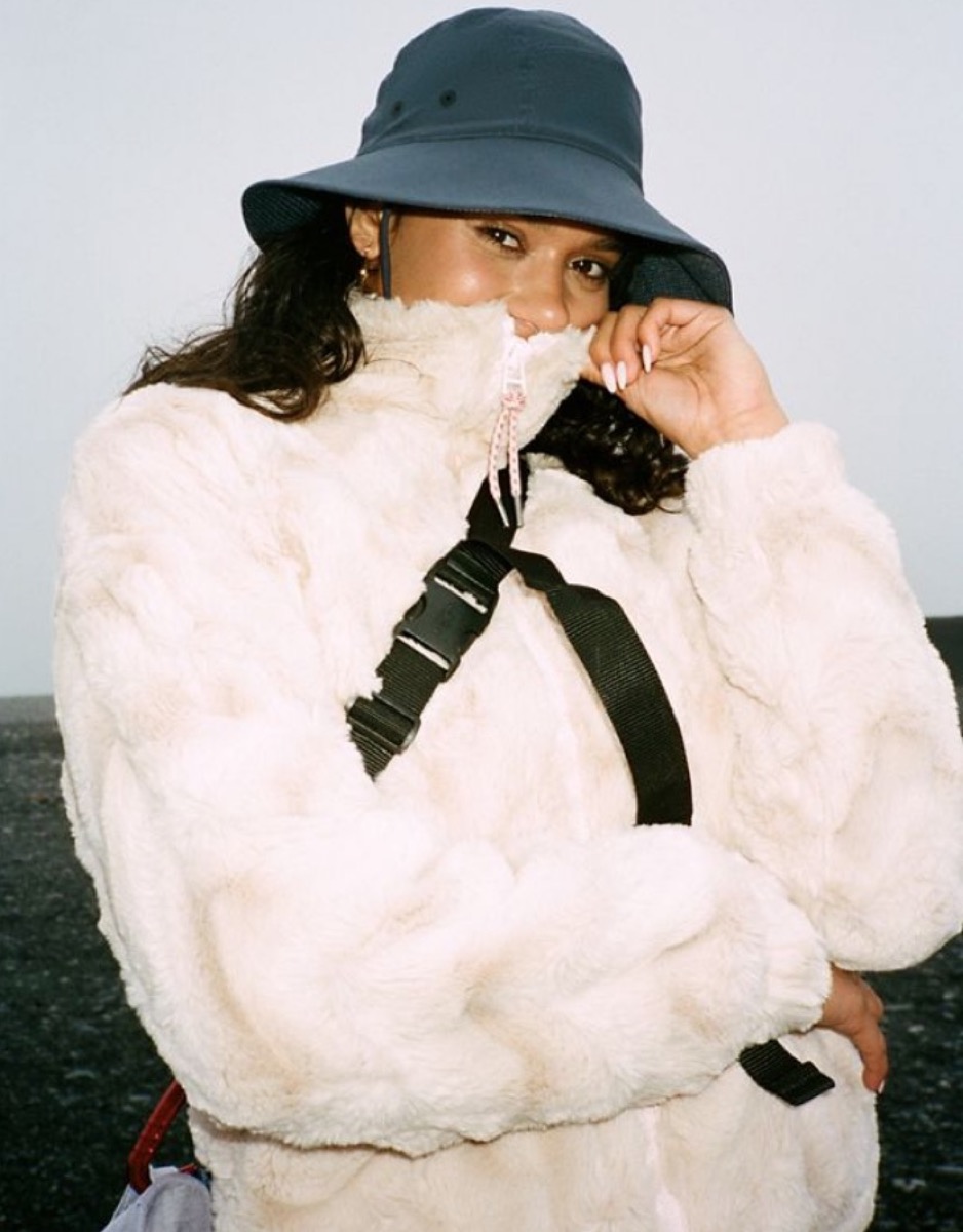 woman in gray hat and white faux fur jacket