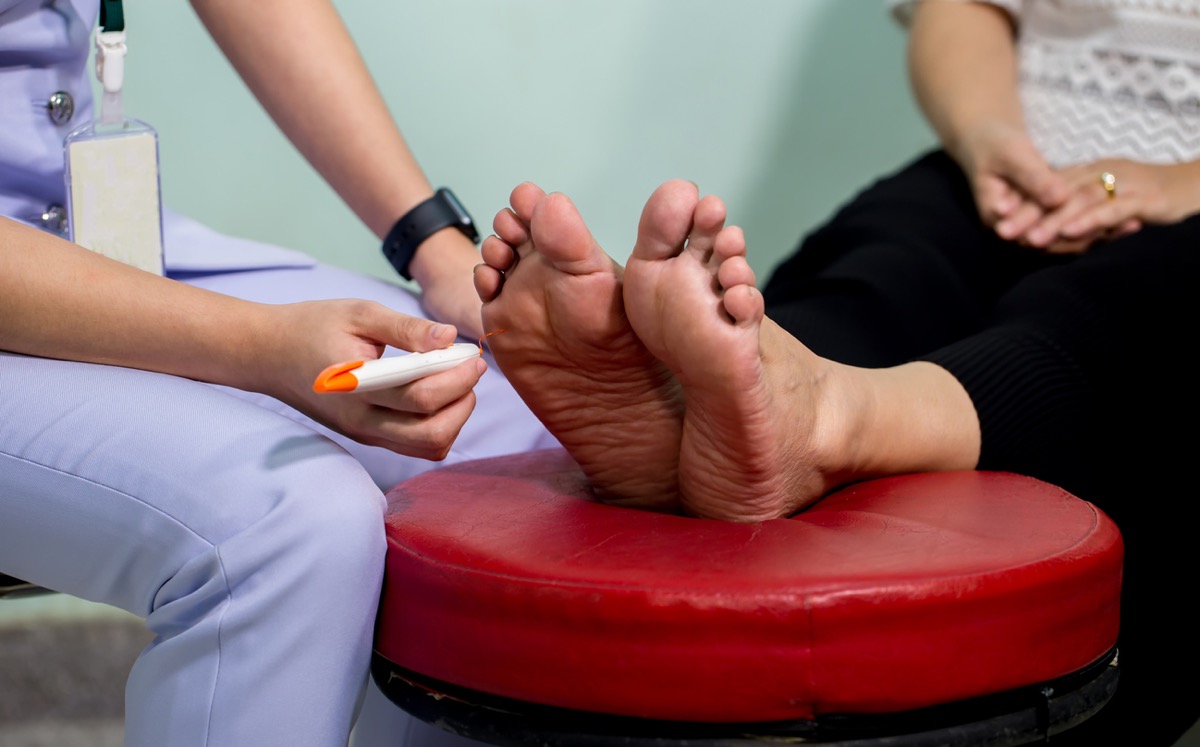 Doctor examining female patient's feet