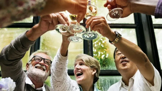 group of older adults drinking a champagne toast