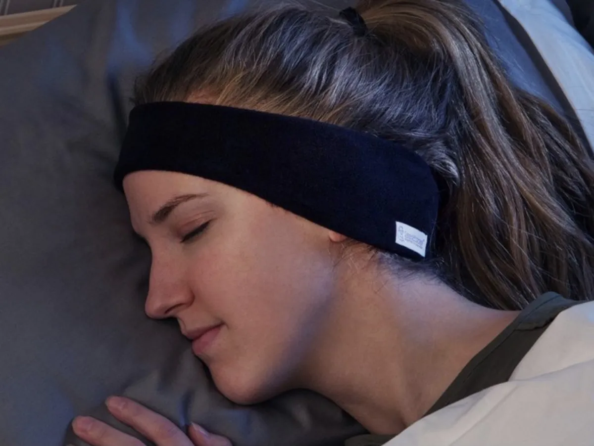 woman sleeping with black headband around her ears, better sleep essentials