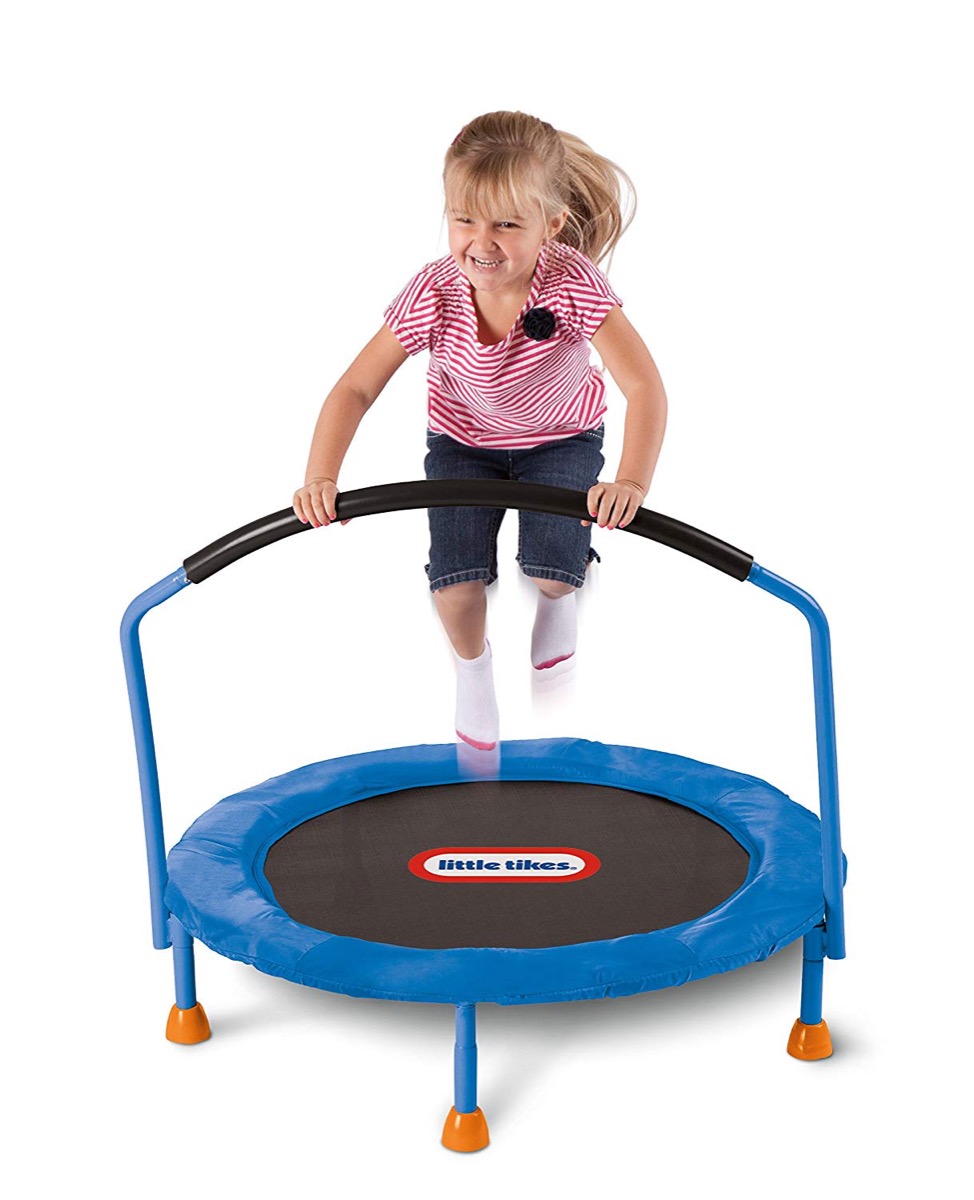 little white girl jumping on blue trampoline