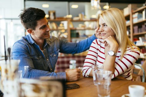 Un cuplu frumos de îndrăgostiți flirtează în restaurant și se leagă