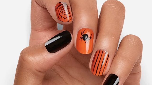 woman's hand with orange and black manicured nails
