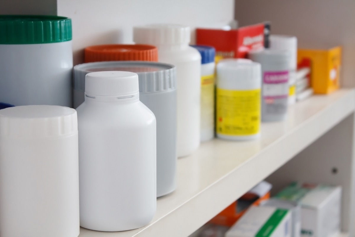 a bunch of unlabeled medicine bottles in a medicine cabinet