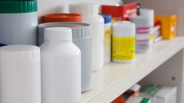 a bunch of unlabeled medicine bottles in a medicine cabinet