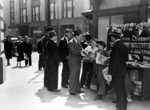 men buying newspapers from newsboys shouting extra extra in the middle of the 20th century