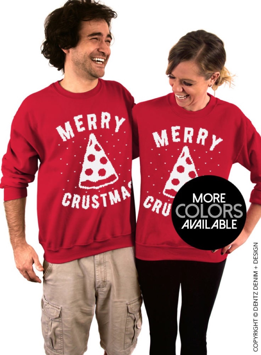 man and woman wearing red sweaters with "merry crustmas" on them