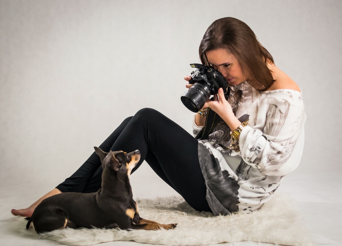 Woman taking a professional photograph of a dog