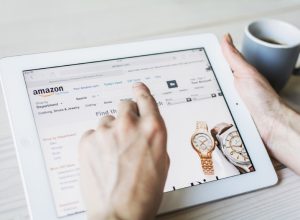 woman's hand clicks on tablet screen while shopping on amazon for watches