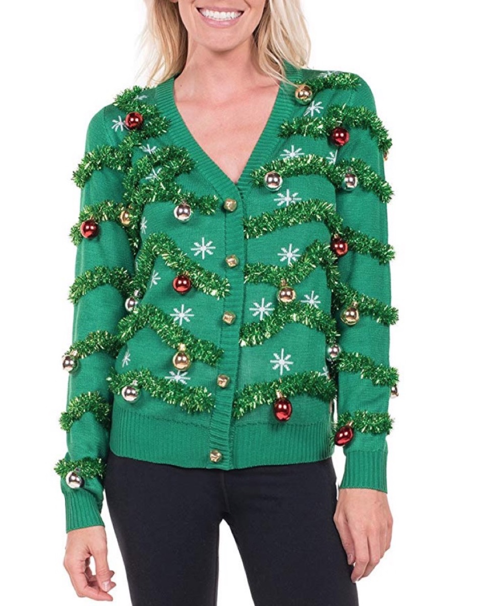woman wearing green cardigan with tinsel and christmas lights