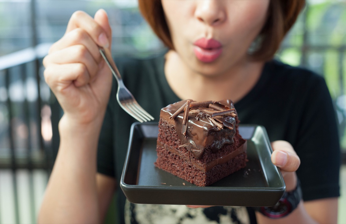 woman eating chocolate cake with a fork