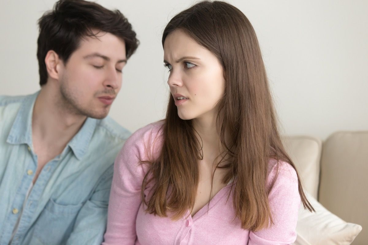 man trying to kiss woman as she looks uncomfortable