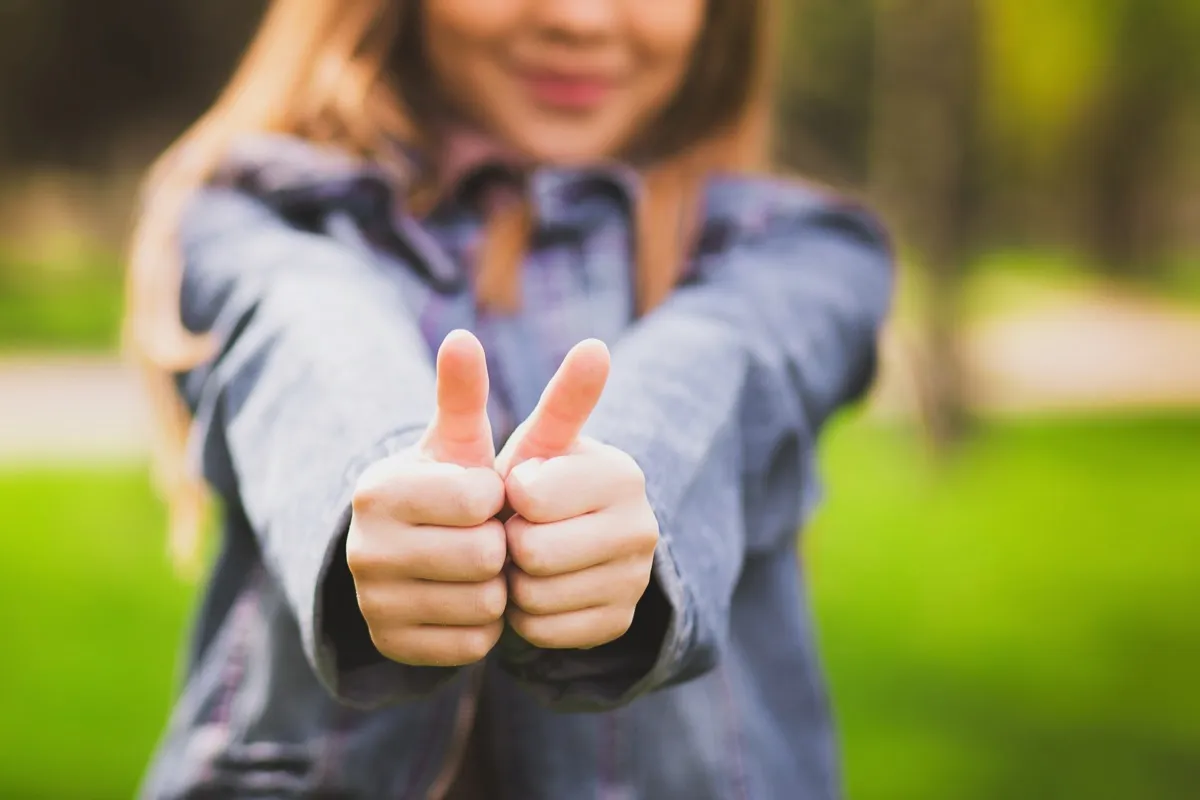 young woman giving thumbs up