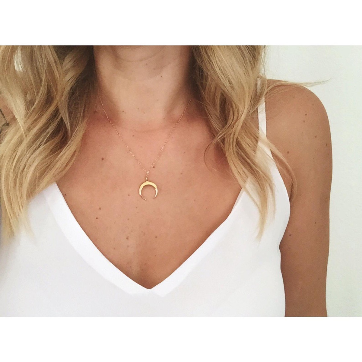 woman wearing gold tusk necklace