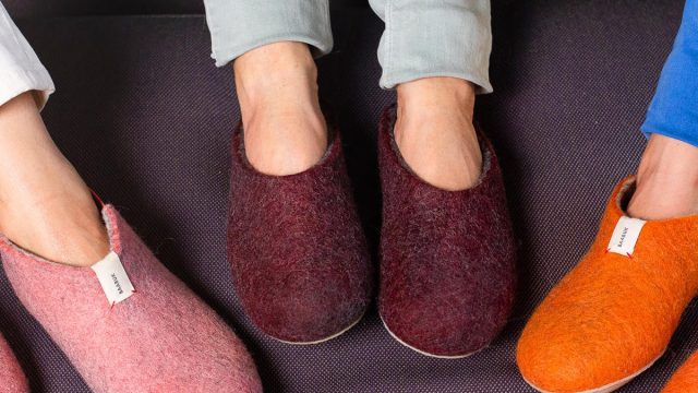 three pairs of feet in pink, burgundy, and orange slippers
