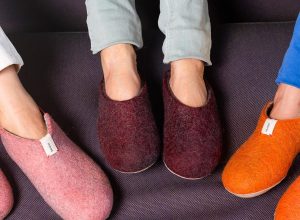 three pairs of feet in pink, burgundy, and orange slippers