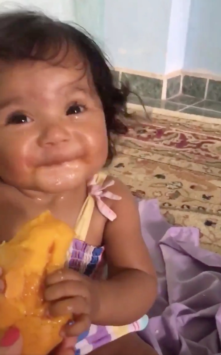 baby trying mango