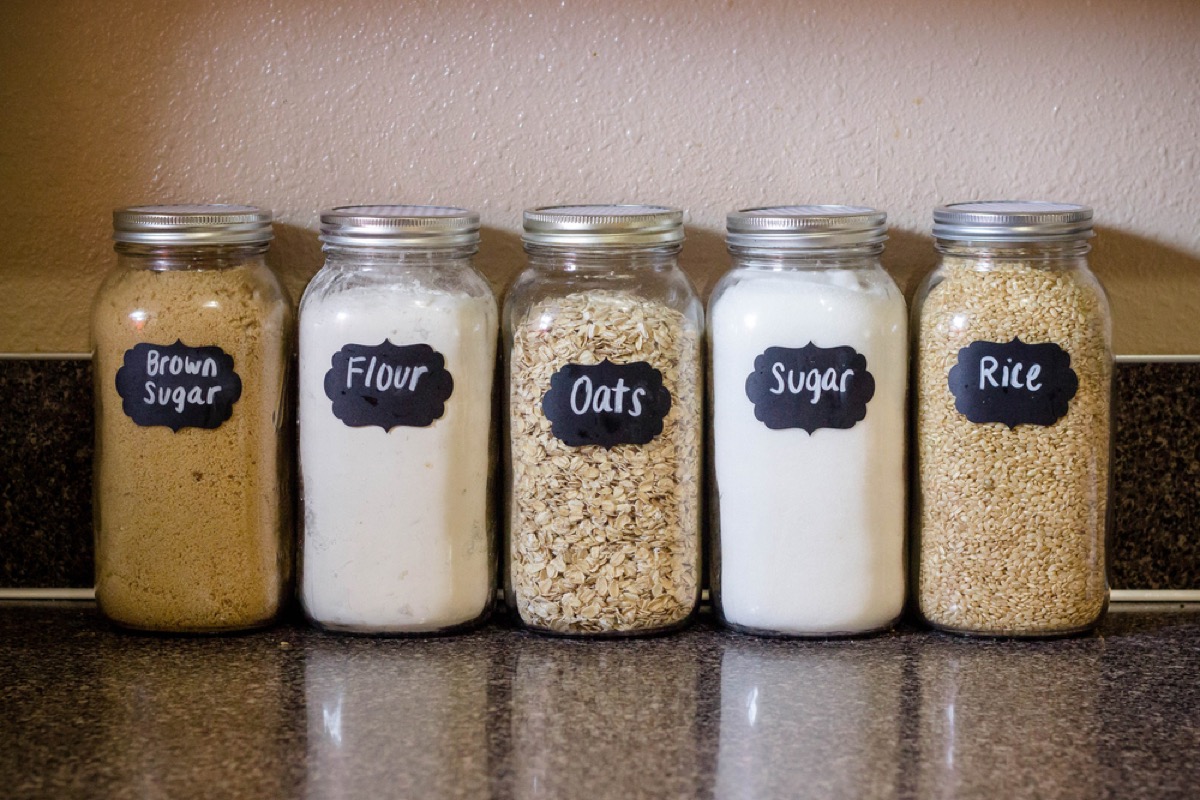 glass jars with flour, sugar, oats, and rice in them on kitchen counter 