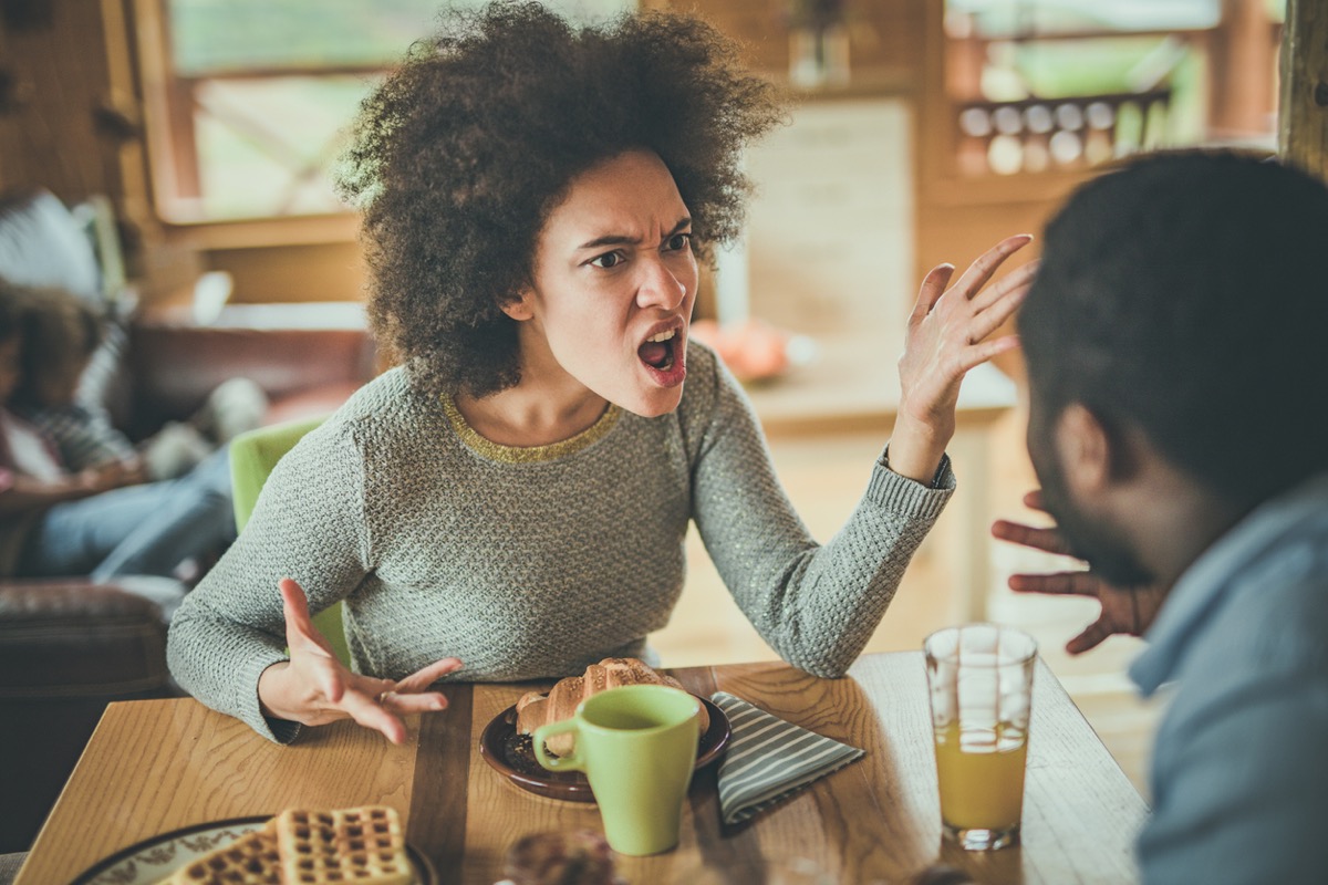 young black woman yelling at black man while eating breakfast