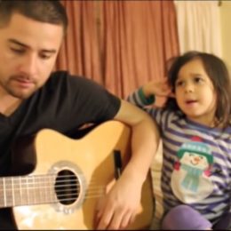 young man playing acoustic guitar next to young girl