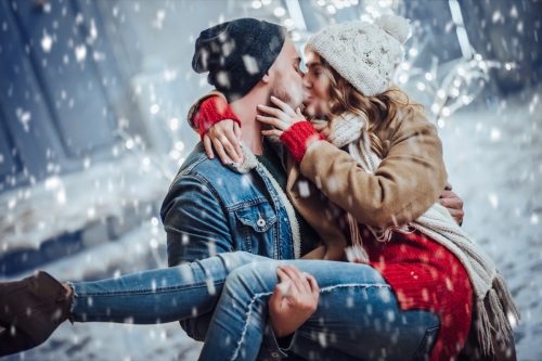 man and woman kissing in winter